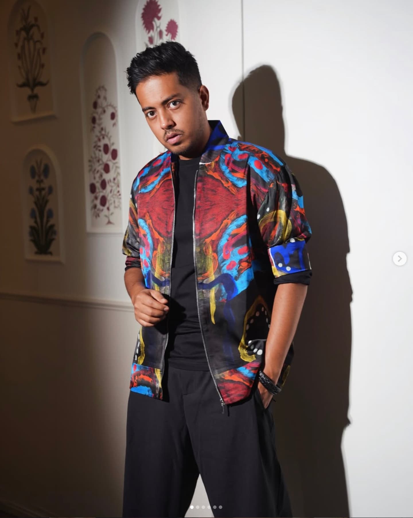 Aakash Gupta in a vividly patterned jacket, standing against a light wall